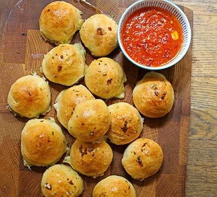 Cheese-stuffed garlic dough balls with a tomato sauce dip